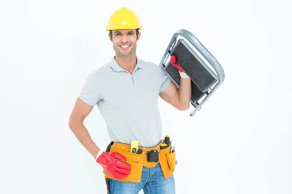 Confident worker carrying step ladder — Stock Photo, Image