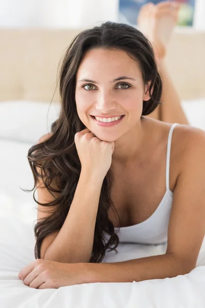 Happy brunetka na posteli — Stock fotografie
