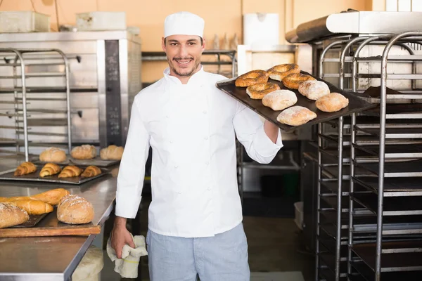 Baker holding tray of bread — Stock Photo, Image