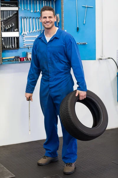 Mechanic holding a tire wheel — Stock Photo, Image