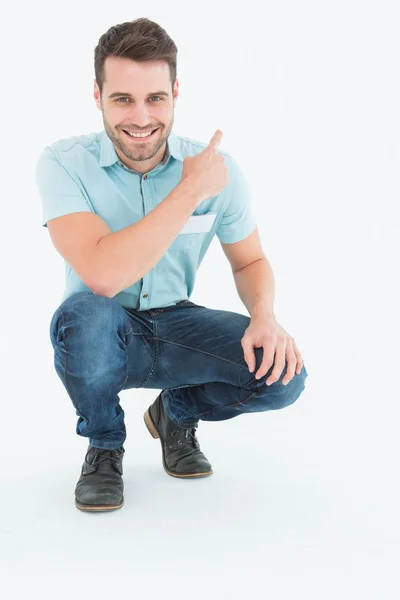 Delivery man pointing backward — Stock Photo, Image