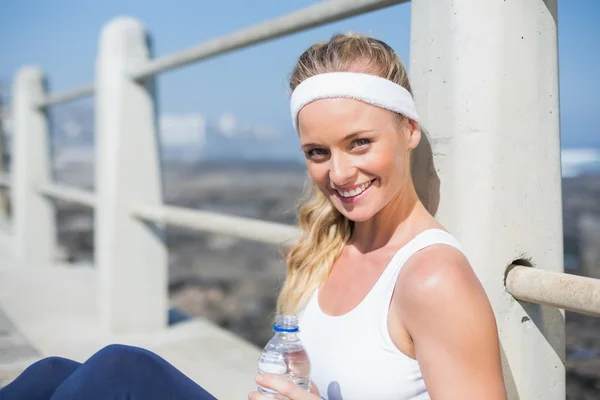 Fit blonde sitting on pier — Stock Photo, Image