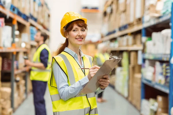 Smiling warehouse manager holding clipboard — Stock Photo, Image