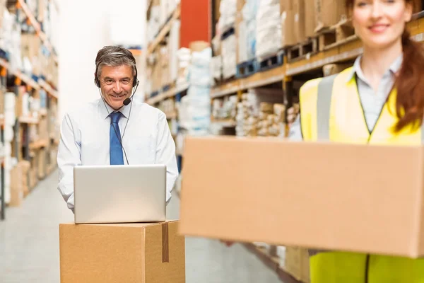 Gerente de almacén sonriente utilizando el ordenador portátil —  Fotos de Stock