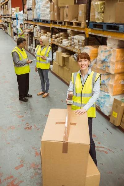 Warehouse worker sealing cardboard boxes for shipping — Stock Photo, Image