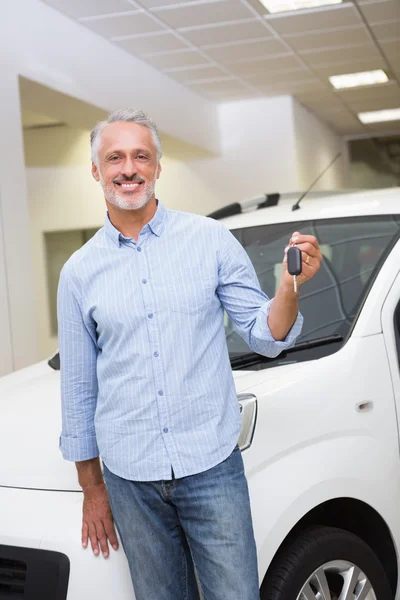 Мужчина водитель показывает ключ после покупки новой машины — стоковое фото
