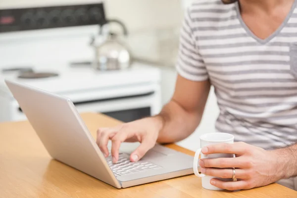 Man using laptop while having coffee — Stock Photo, Image