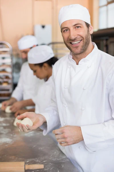 Equipo de panaderos trabajando en el mostrador — Foto de Stock