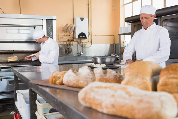 Baker making dough in mixing bowl — Stock Photo, Image