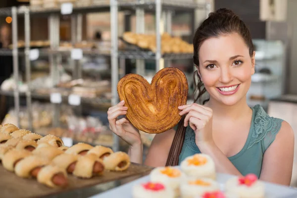 Brunette tenant pâtisserie en forme de coeur — Photo