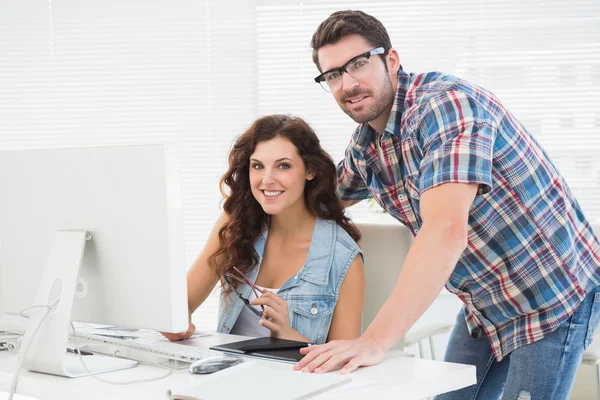 Socios sonrientes usando la computadora juntos —  Fotos de Stock