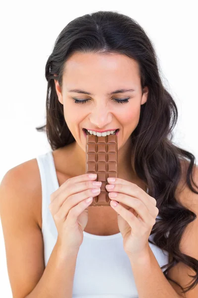Bonita morena comiendo barra de chocolate — Foto de Stock