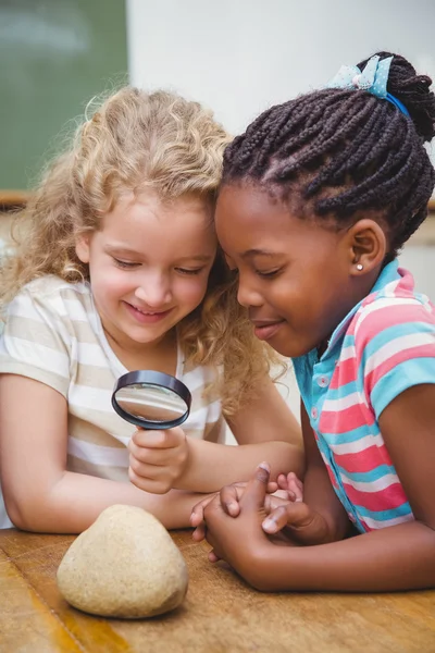 Cute pupils looking through magnifying glass — Stock Photo, Image