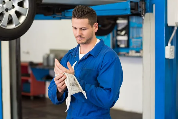 Mechanic wiping hands with rag — Stock Photo, Image