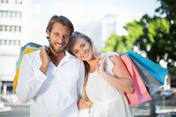 Couple smiling holding bags — Stock Photo, Image