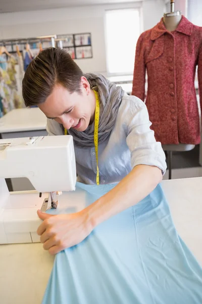 Усміхнений студент використовує швейну машину — стокове фото