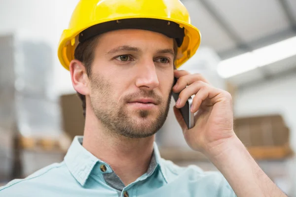 Werknemer met behulp van mobiele telefoon in magazijn — Stockfoto