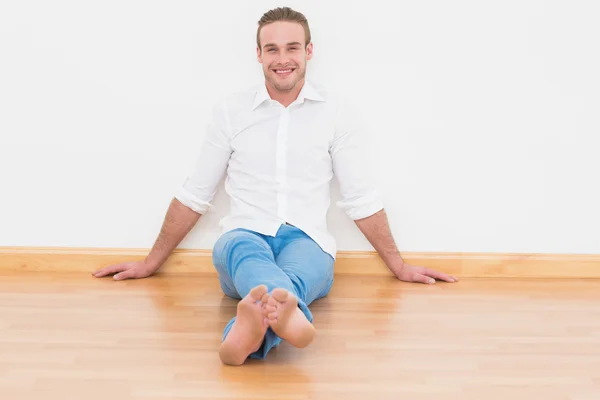 Casual man sitting on floor at home — Stock Photo, Image