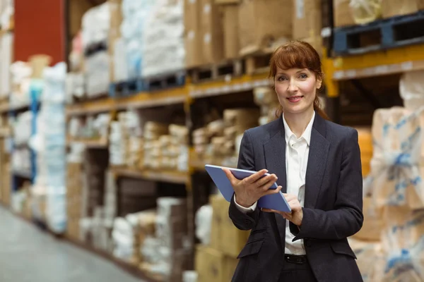 Femme d'affaires souriante défilant sur tablette numérique — Photo