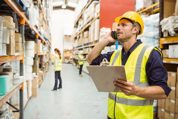 Trabajador de almacén hablando por teléfono — Foto de Stock