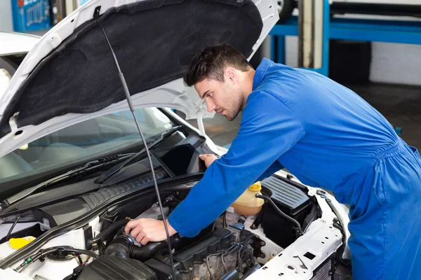 Mecánico examinando bajo el capó del coche — Foto de Stock