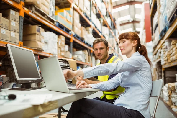 Trabajador de almacén y gerente mirando portátil — Foto de Stock