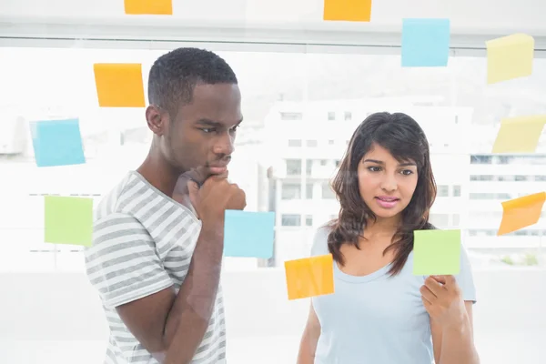 Concentrated coworkers reading sticky words — Stock Photo, Image