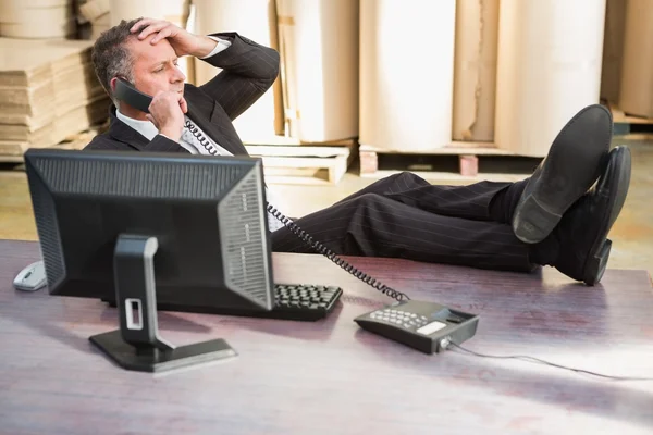 Gerente de armazém usando telefone na mesa — Fotografia de Stock