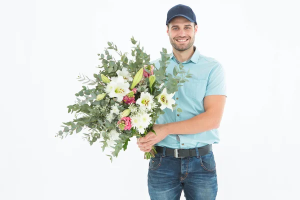 Happy delivery man holding bouquet — Stock Photo, Image