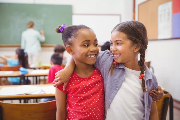 Mignons élèves souriant à la caméra dans la salle de classe — Photo