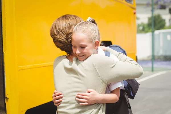 Mère étreignant sa fille par autobus scolaire — Photo