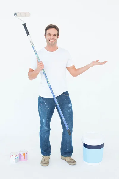 Man gesturing while holding paint roller — Stock Photo, Image