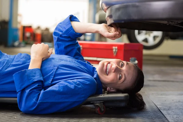Mechanic lying and working under car — Stock Photo, Image