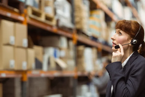 Mulher de negócios bonita falando em um fone de ouvido — Fotografia de Stock