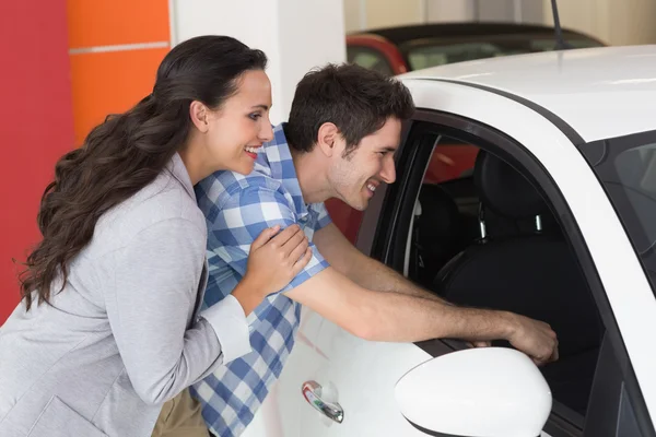 Lachende paar op zoek in een auto — Stockfoto