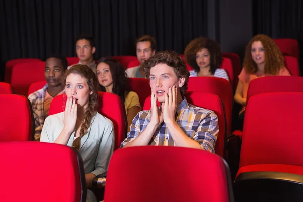 Surprised young friends watching a film — Stock Photo, Image