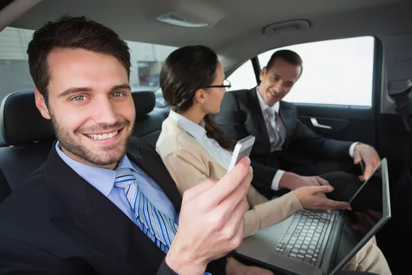 Equipo de negocios trabajando en el asiento trasero — Foto de Stock