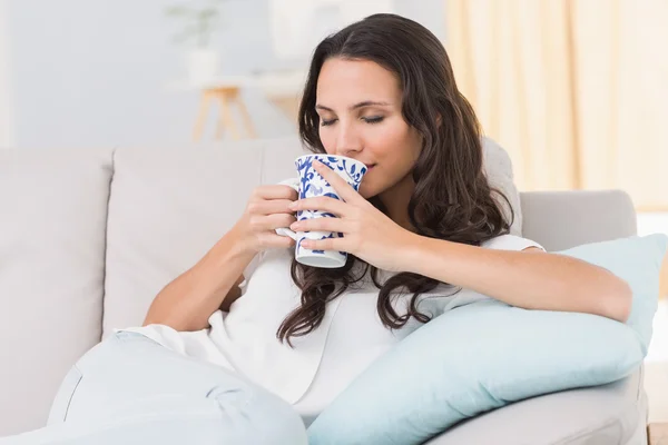Morena tomando café en el sofá —  Fotos de Stock