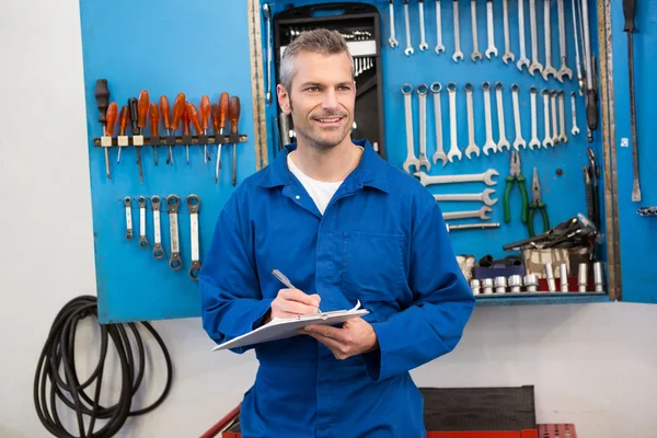 Mechanic writing on clipboard — Stock Photo, Image