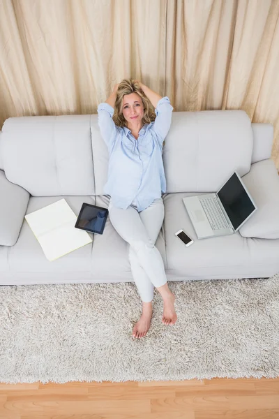 Blondin på soffa nära wirelesses teknik — Stockfoto