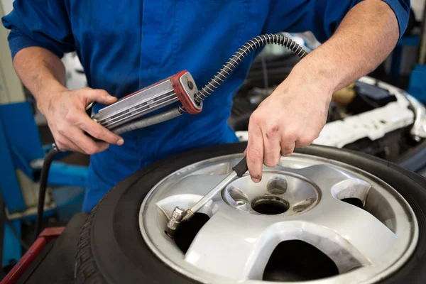 Mechanic inflating the tire — Stock Photo, Image
