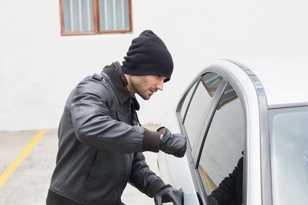 Thief breaking into car with fist — Stock Photo, Image