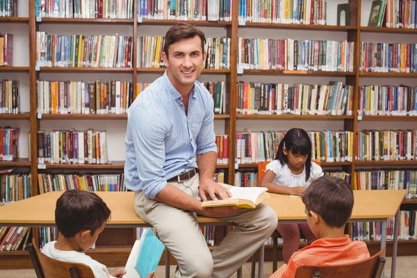 Cute pupils and teacher having class in library — Stock Photo, Image