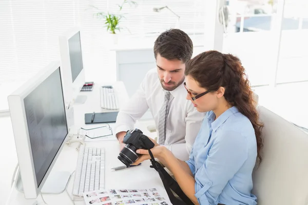 Concentrated coworkers holding digital camera — Stock Photo, Image