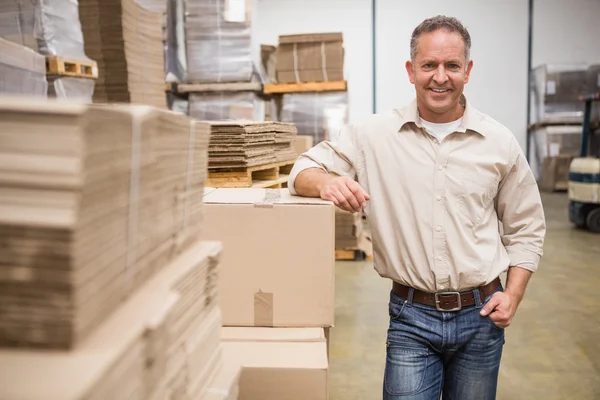 Warehouse worker leaning against boxes — Stock Photo, Image