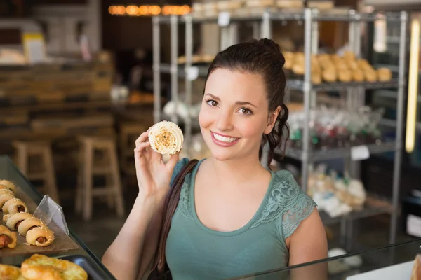 Mooie brunette tonen een cupcake — Stockfoto