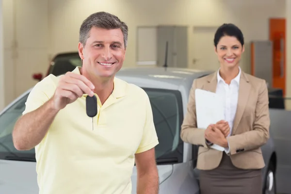 Client souriant montrant sa nouvelle clé de voiture — Photo