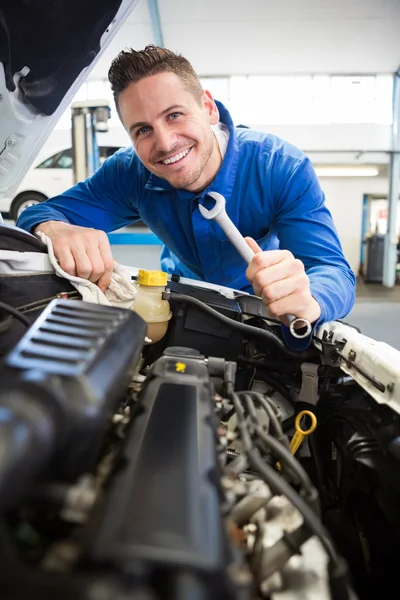 Mecânico sorrindo para câmera de fixação do motor — Fotografia de Stock