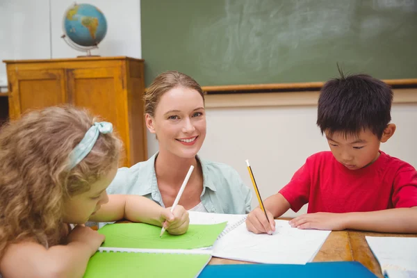 Carina insegnante aiutare allievo in classe — Foto Stock