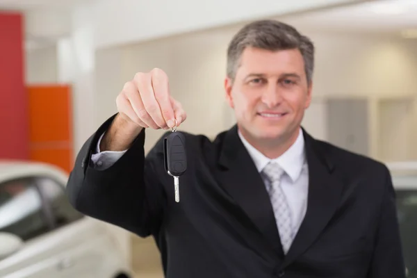 Продавець тримає ключ клієнта автомобіля — стокове фото
